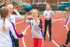 Lapsia yleisurheilukentällä heittämässä palloa